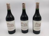 trois bouteilles de vin posées sur une table l'une à côté de l'autre