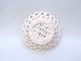 a white crochet brooch on a white surface