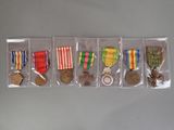 five medals in a row on display in a case