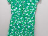 a green dress with white flowers on it hanging on a hanger
