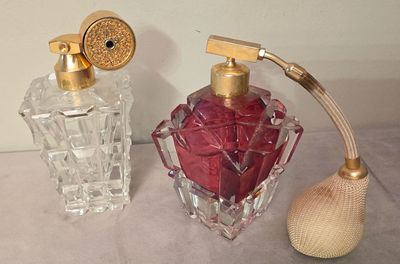 two perfume bottles sitting next to each other on a table