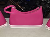three pairs of pink shoes sitting on a table