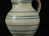 a blue and white striped vase on a black surface