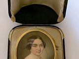 an old picture of a woman in a black dress in a case