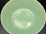 green bowl on a black table with a black background