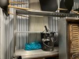 a shelf with pots and pans on it in a kitchen