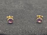 une paire de boucles d'oreilles en améthore sur un fond noir