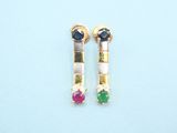a pair of earrings with multi colored stones on a blue surface