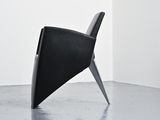 a black chair that is sitting in the middle of a room