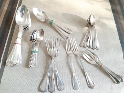 beaucoup de cuillères et de couverts en argent sur une table