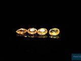a group of three yellow sapphires on a black surface