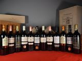 many bottles of wine sitting on a table with a red cloth