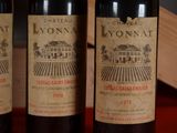 three bottles of wine sitting on top of a table next to a wooden box