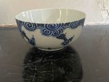 a blue and white bowl sitting on a black table