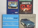 trois livres posés sur une table blanche, avec une voiture bleue devant
