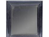 un gros plan d'un miroir au cadre noir sur fond blanc
