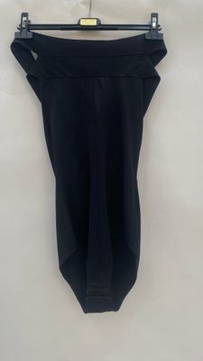 a black dress hanging on a white wall with a black hanger
