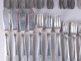 a lot of forks and spoons laid out on the table