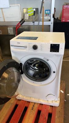 une machine à laver posée sur une palette dans un entrepôt