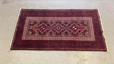 un tapis rouge et noir posé au sol dans une pièce