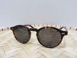 un gros plan sur une paire de lunettes de soleil posée sur un panier tressé