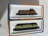 deux trains miniatures posés dans une boîte sur une table