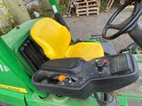 a green tractor with a yellow seat and steering wheel
