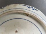 a close up of a blue and white plate with writing on it
