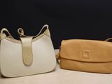two purses sitting on a table next to each other on a table