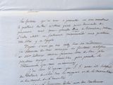 an old letter with writing on it sitting on top of a table