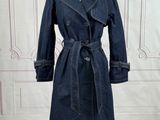 denim trench coat on a mannequin stand in front of a white wall
