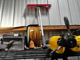 un tuyau jaune posé sur une table, à côté d'un sac à outils