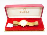 une image représentant une montre en or dans un coffret rouge posé sur une surface blanche