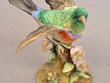 a figurine of a bird sitting on a tree branch