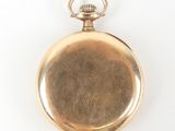 an old gold pocket watch with a chain on a white surface