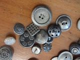 a lot of buttons on a wooden table