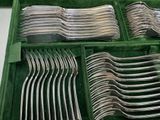 many forks and spoons in a green case