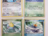 Quatre cartes Pokémon sont représentées sur une surface blanche