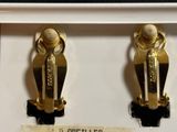 two pairs of gold earrings on display in a display case