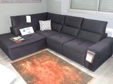 un canapé modulable noir dans un salon avec un tapis rouge