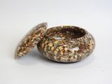 a small bowl with a lid on a white surface