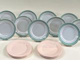 six pink and green plates are lined up on a white surface
