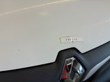 a close up of a white car with a red emblem on it