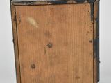 a small wooden box with a metal lid on a white surface