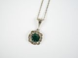 an emerald and diamond pendant on a chain