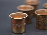 several cups of tea are lined up on a table
