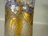 a glass vase with flowers and leaves on it on a table