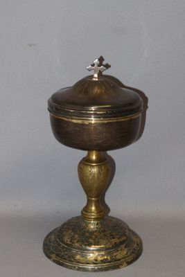 a small metal bowl with a lid sitting on a table