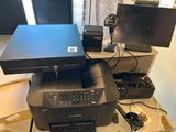 une imprimante posée sur un bureau, à côté d'un écran