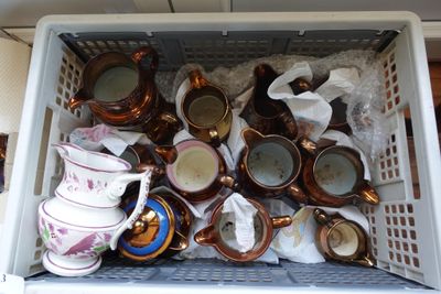 de nombreuses tasses et soucoupes dans un panier posé sur la table